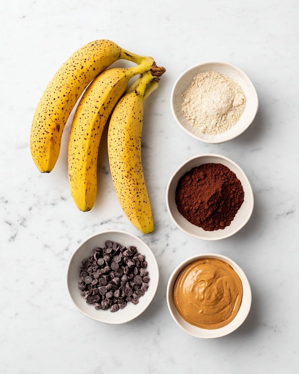 The image shows five ingredients on a white marbled surface. On the left side, there are three yellow bananas with small brown spots. To the right of the bananas, there are four small white bowls arranged in a loose diamond shape. The top bowl contains a light beige powder with a crumbly texture. The bowl below it holds dark brown cocoa powder with a dry, smooth surface. The bowl on the bottom left has small dark chocolate chips, and the bottom right bowl is filled with smooth, light brown peanut butter. photo taken with an iphone --ar 4:5 --v 7